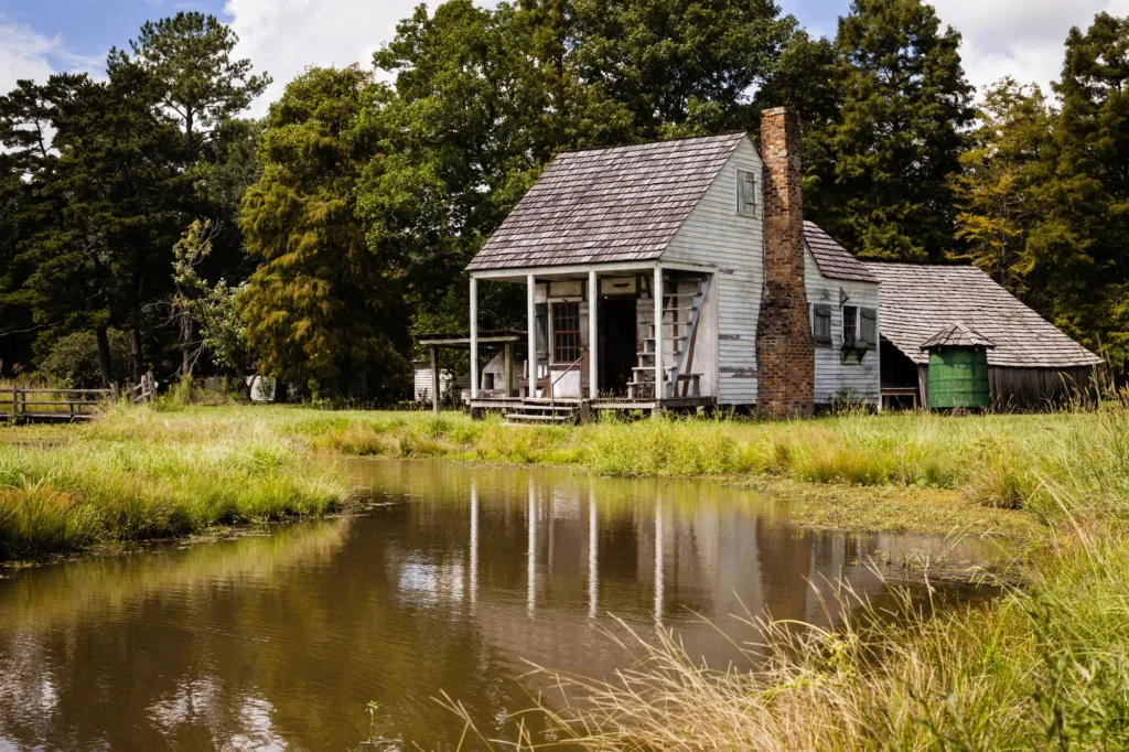 Historic home with grass on the bank of a lake at Rural Life Museum 